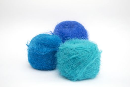 Three balls of blue yarn on a white background