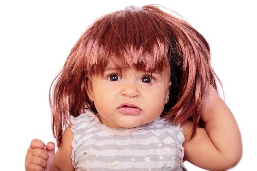 portrait of an angry baby with a wig