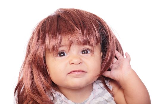 portrait of an angry baby with a wig