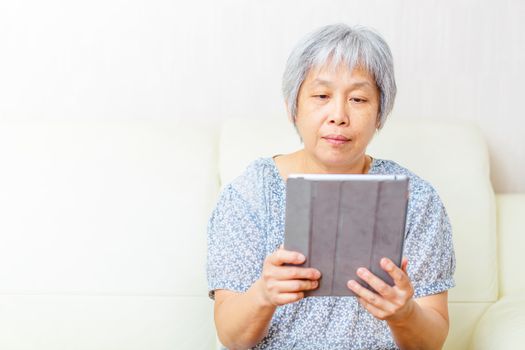 Asian old woman using tablet