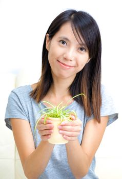 Asian woman holding potted plant
