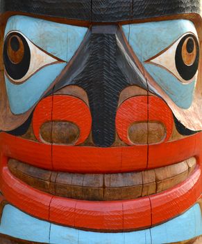 Detail Of A Brightly Painted Face On A Totem Pole