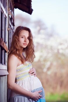Beautiful pregnant girl near the old house