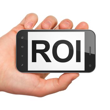 Finance concept: hand holding smartphone with word ROI on display. Mobile smart phone in hand on White background, 3d render