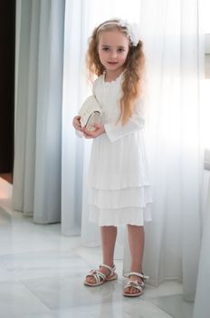 Portrait of beautiful girl standing near white curtain