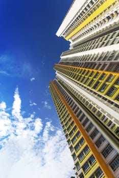 An extreme low angle shot of a new colorful high rise apartment against the sky.