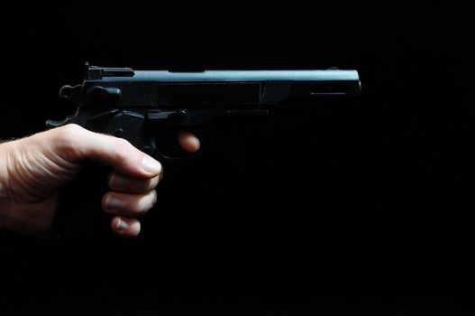 Gun and a Hand on a Black Background