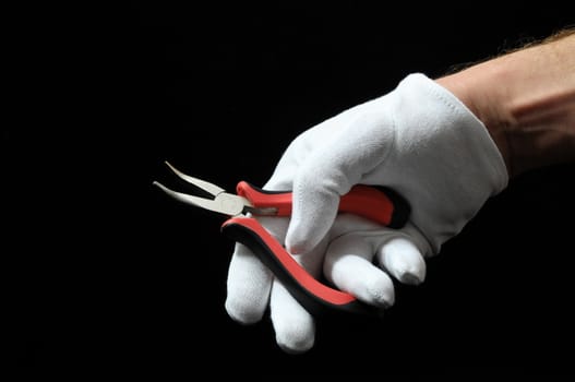 Pliers and a Hand on a Black Background