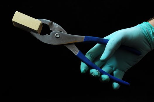 Pliers and a Hand on a Black Background