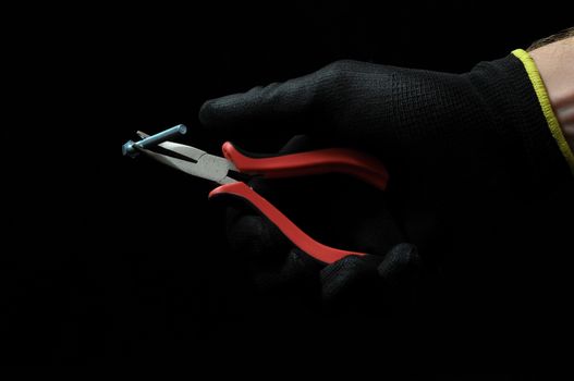 Pliers and a Hand on a Black Background