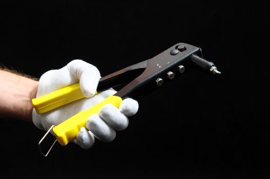 Rivets Pliers and a Hand on a Black Background