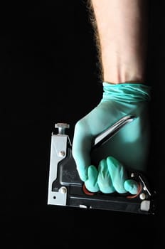 Stapler Pliers and a Hand on a Black Background