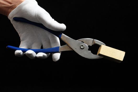 Pliers and a Hand on a Black Background