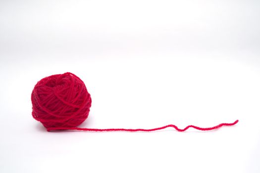 Red ball of wool creating a heart shape