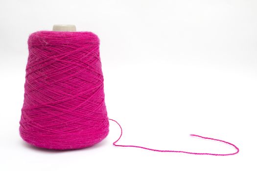 Cone of pink wool unravelled on a white background