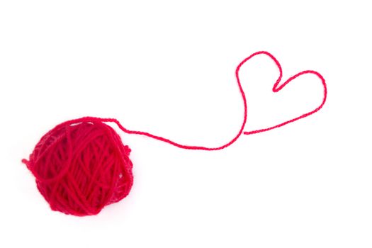 Red ball of wool creating a heart shape