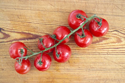 Vine of tomatoes on a wooden board