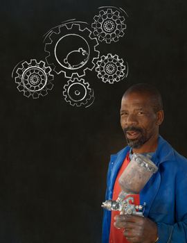 African American black man industrial worker with chalk hamster gears on a blackboard background