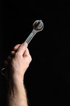 One Key Bolts and a Hand on a Black Background