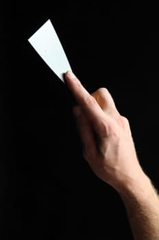 One Spatula and a Hand on a Black Background