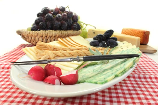 a white plate of various cheeses