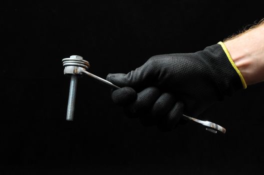 One Key Bolts and a Hand on a Black Background