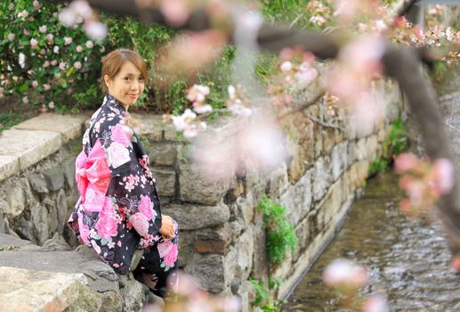 Young woman wearing Japanese kimono with cherry blossom