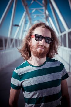 stylish hipster model with long red hair and beard lifestyle in the street