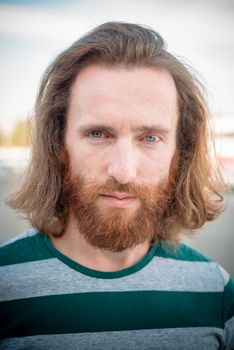 stylish hipster model with long red hair and beard lifestyle in the street