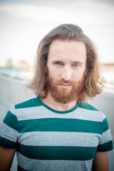 stylish hipster model with long red hair and beard lifestyle in the street