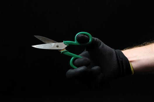 Scissors and a Hand on a Black Background