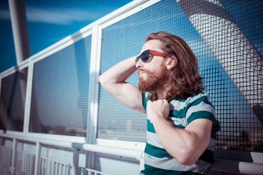 stylish hipster model with long red hair and beard lifestyle in the street