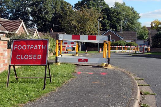 Road work warning signs and barriers in a street in England.