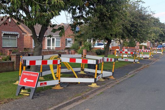 Road work warning signs and barriers in a street in England. 