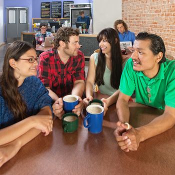 Wide angle view of four people talking in a coffee house