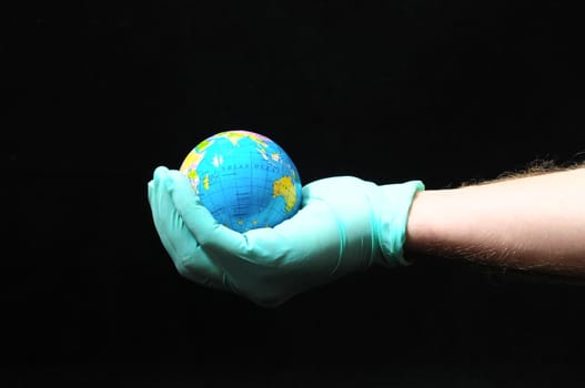 Planet Earth and a Hand on a Black Background