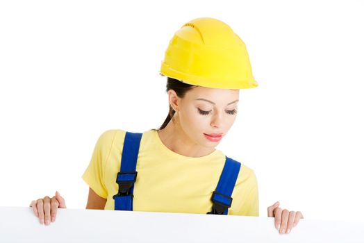 Female construction worker with blank board, isolated on white