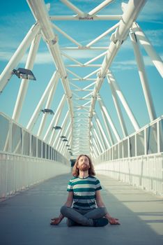 stylish hipster model with long red hair and beard yoga in the street