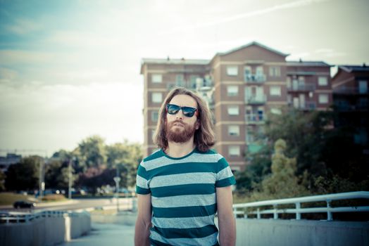 stylish hipster model with long red hair and beard lifestyle in the street