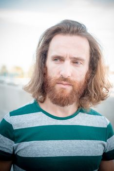 stylish hipster model with long red hair and beard lifestyle in the street