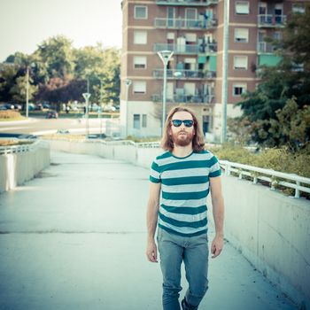 stylish hipster model with long red hair and beard lifestyle in the street