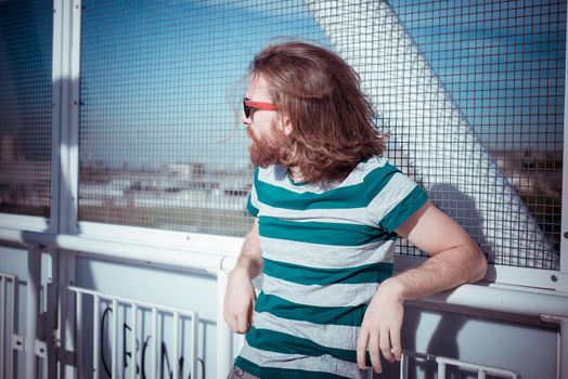 stylish hipster model with long red hair and beard lifestyle in the street