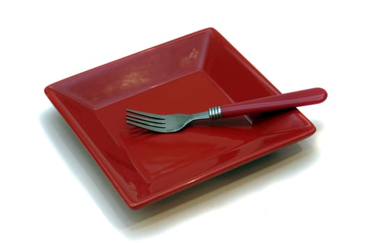 Red dessert plate and fork isolated on white