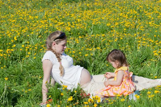 Young mother with the small daughter on summer walk