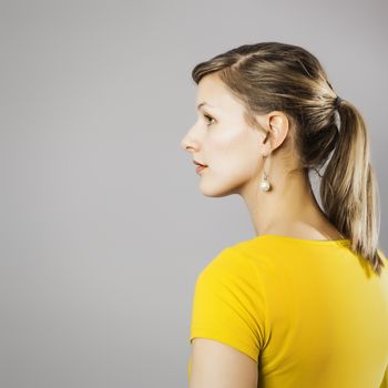 A beautiful woman in a yellow shirt sideview