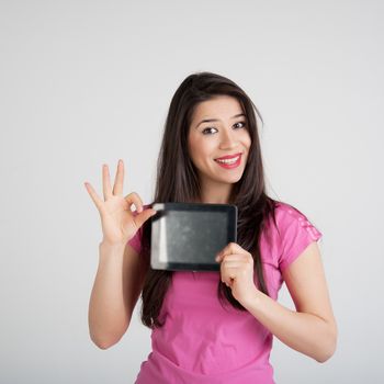 beautiful woman in pink t-shirt is pleased tablet