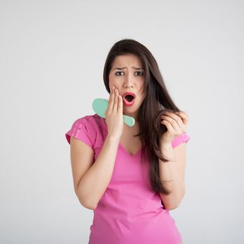 shocked woman losing hair on hairbrush