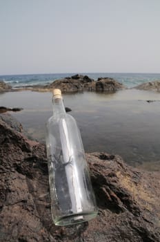 Message in the Bottle on the Rocks near the Beach