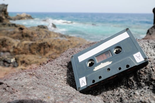 Ancient Retro Musicassette on the Rocks near the Beach