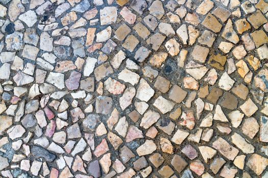 The cobblestone road is made of pebbles, closeup backdrop 
